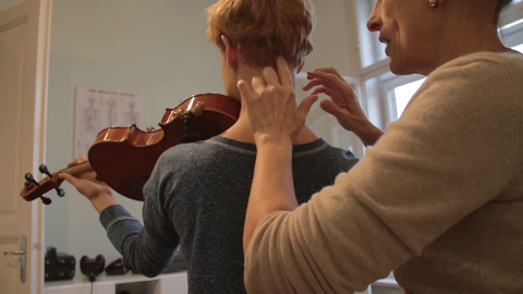 Učiteljica Alexander tehnike poučava posturu glazbenicu koja svira violinu.