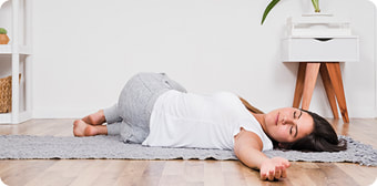 Lijepa mlada žena leži i odmara na podu nakon vježbanja. 