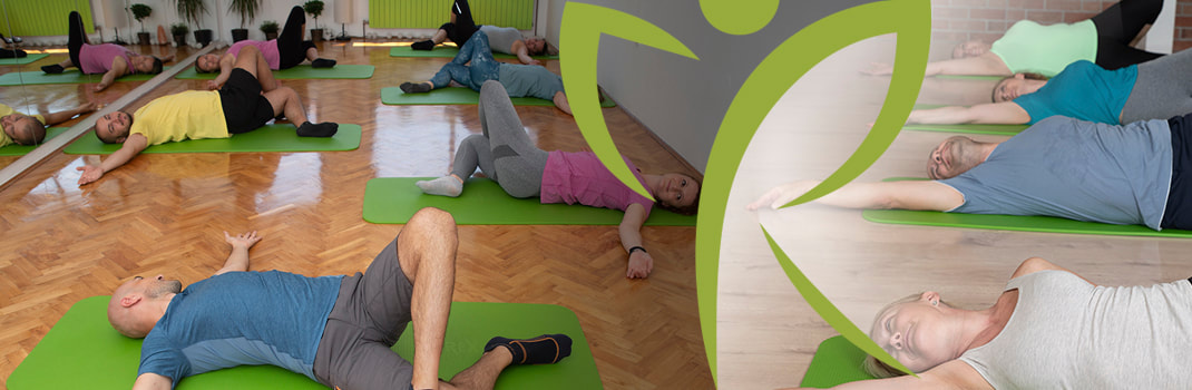 Grupe muškaraca i žena na zelenim prostirkama uz ogledalo rade vježbe istezanja za fleksibilnost cijelog. 