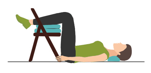 Osoba koja leži na podu s nogama na stolici kako bi ublažila bol od išijasa. 