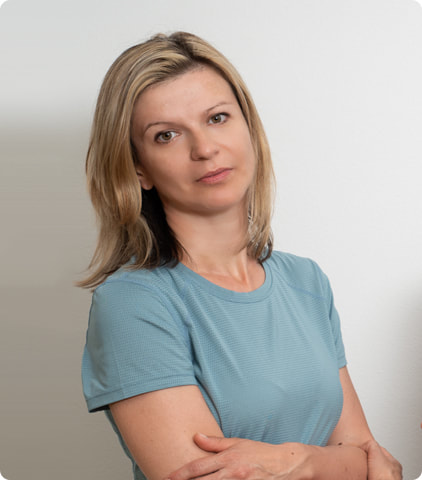Fizioterapeut Ana Horvat u plavoj majici ispred bijele pozadine. 